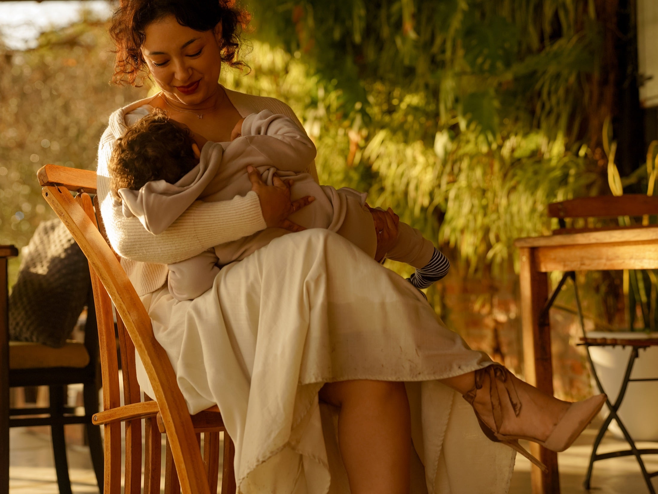 Mother breastfeeding her child in a garden